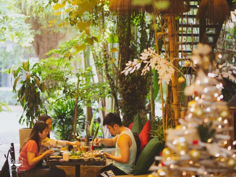 Góc trang trí nghệ thuật cổ điển với tranh treo tường và bình gốm truyền thống tại nhà hàng Quán Bụi Garden