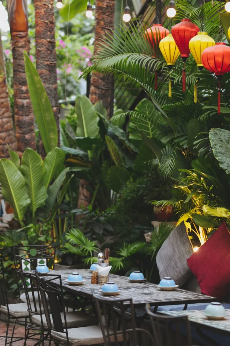 Không gian bàn ăn cạnh cửa sổ đón ánh sáng tự nhiên thông thoáng tại nhà hàng Quán Bụi Garden