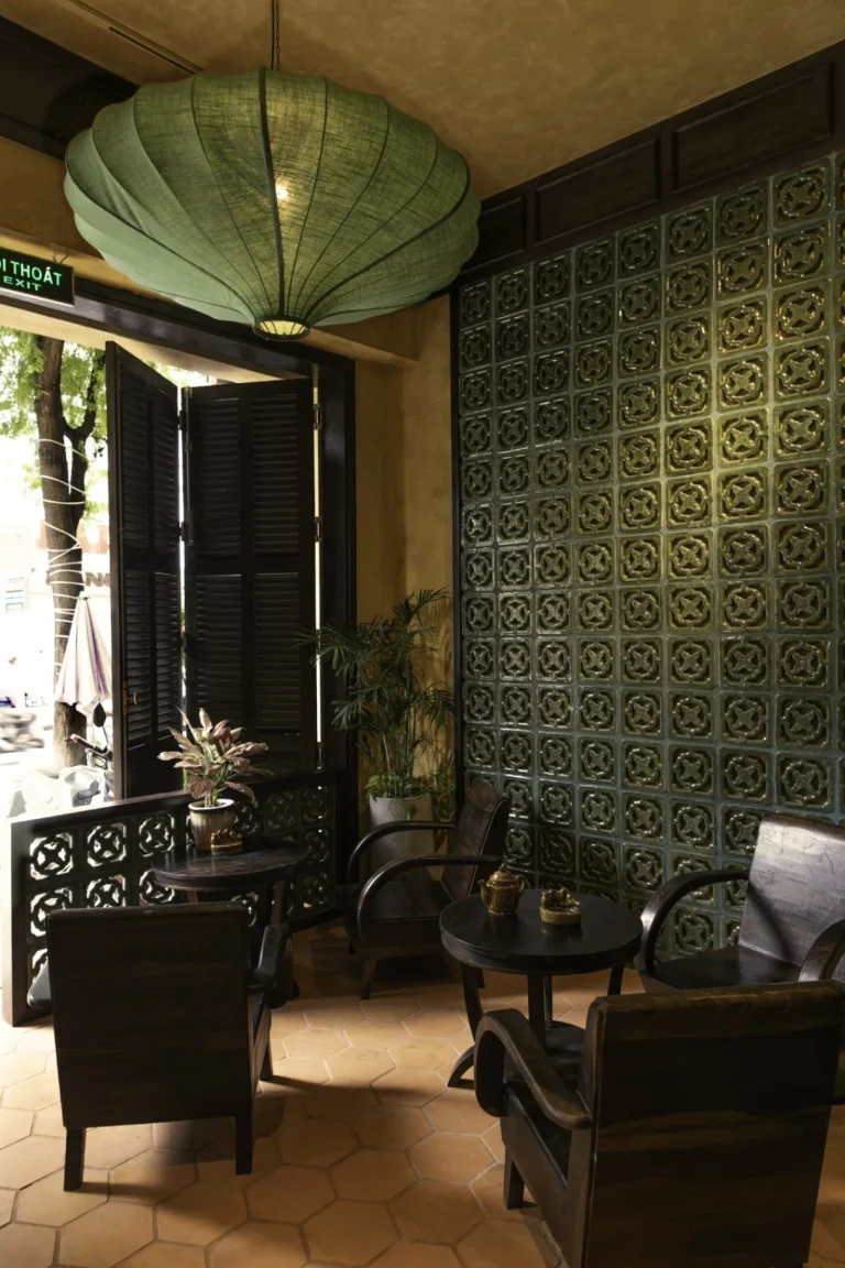 Góc trang trí bình hoa sen thanh tịnh bên cạnh ô cửa kính màu tròn tại nhà hàng Quán Bụi Lê Thánh Tôn