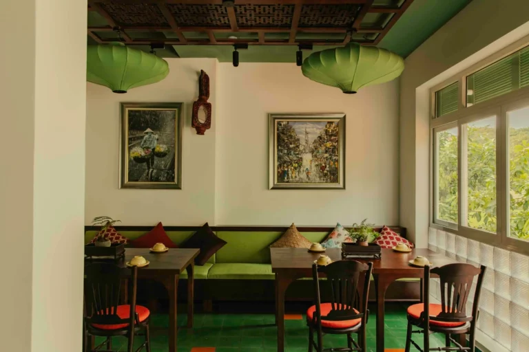 Góc trang trí nghệ thuật cổ điển với tranh treo tường và bình gốm truyền thống tại nhà hàng Quán Bụi Phú Mỹ Hưng