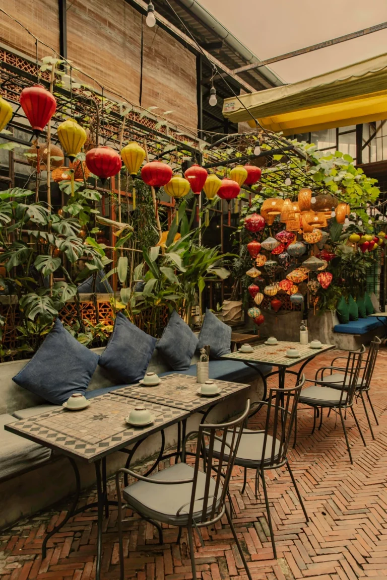 Không gian bàn ăn cạnh cửa sổ đón ánh sáng tự nhiên thông thoáng tại nhà hàng Quán Bụi Garden