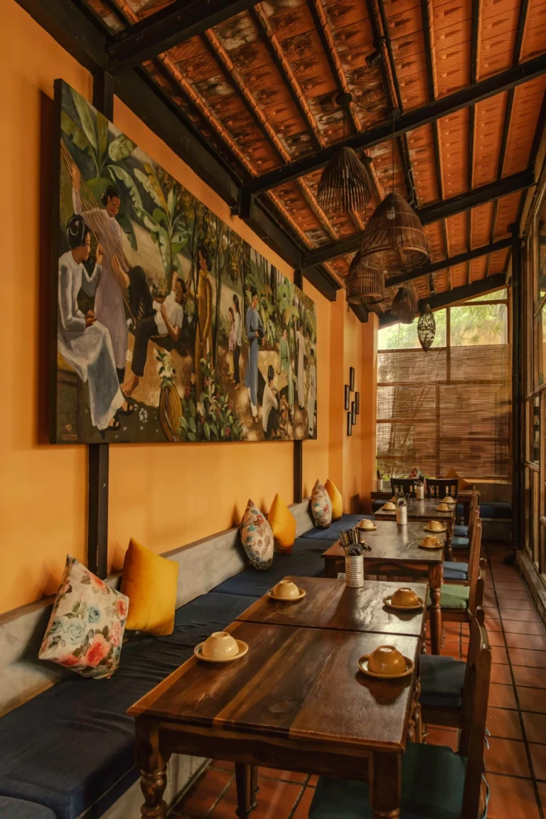 Góc trang trí bình hoa sen thanh tịnh bên cạnh ô cửa kính màu tròn tại nhà hàng Quán Bụi Garden