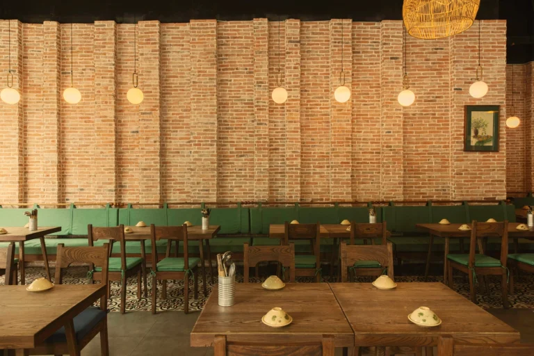 Góc trang trí bình hoa sen thanh tịnh bên cạnh ô cửa kính màu tròn tại nhà hàng Quán Bụi Express