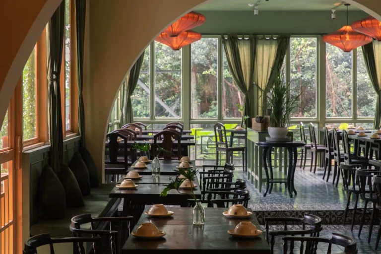 Không gian bàn ăn cạnh cửa sổ đón ánh sáng tự nhiên thông thoáng tại nhà hàng Quán Bụi Central