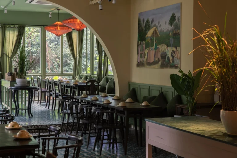 Góc trang trí nghệ thuật cổ điển với tranh treo tường và bình gốm truyền thống tại nhà hàng Quán Bụi Central