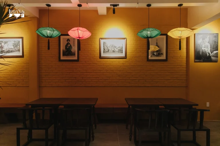 Không gian bàn ăn cạnh cửa sổ đón ánh sáng tự nhiên thông thoáng tại nhà hàng Quán Bụi Garden
